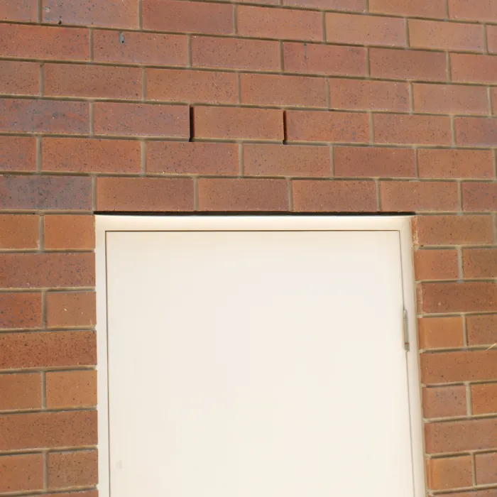 Two brick wall weep holes positioned above a door.