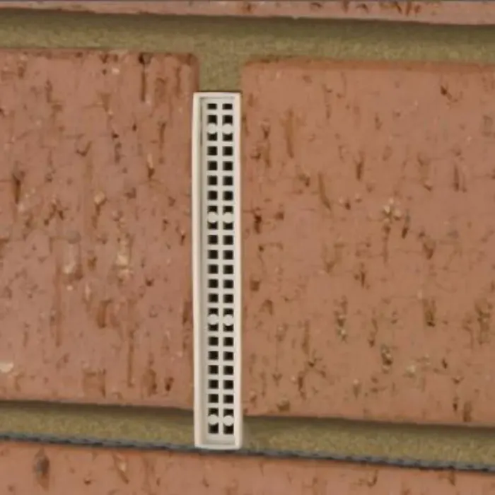White brick weep vents installed in light coloured brickwork.