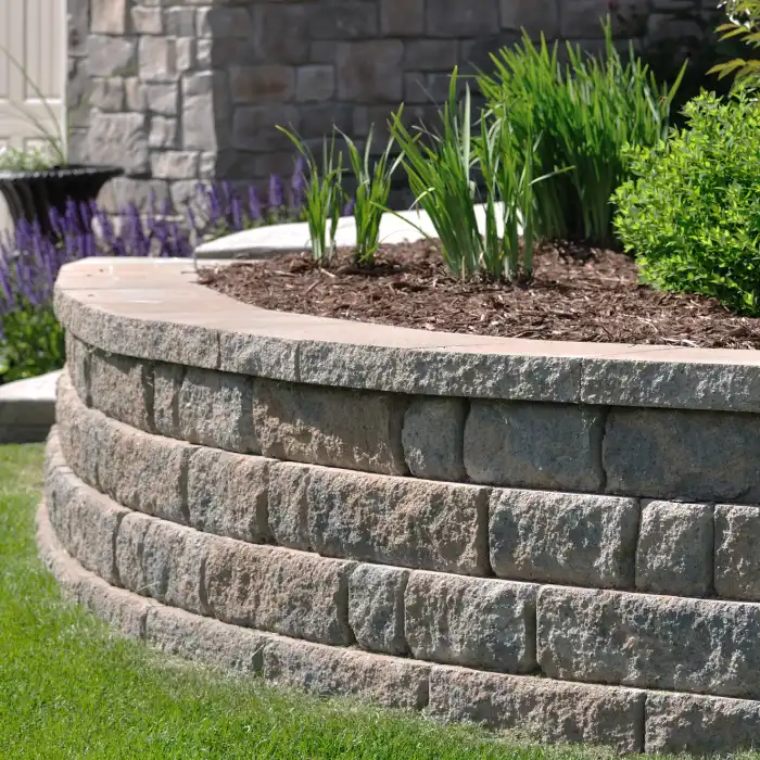 Retaining wall weep holes on a curved stone block garden wall.