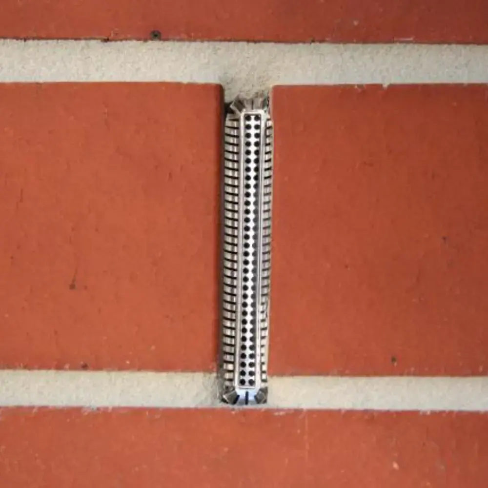 Weepa Protector Weep Ale Screen installed in a red brick wall.