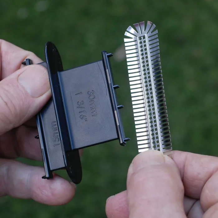 A stainless steel cover being held in a hand before installation.